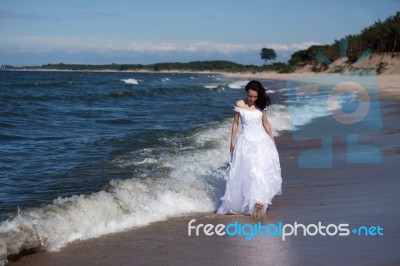 Young Girl Walking Along The Seashore Stock Photo