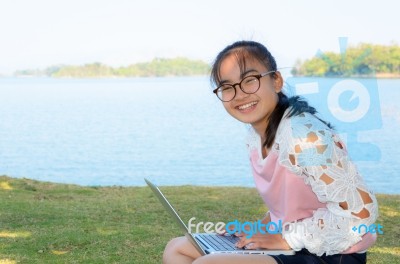 Young Girl With Laptop On The Grass Stock Photo