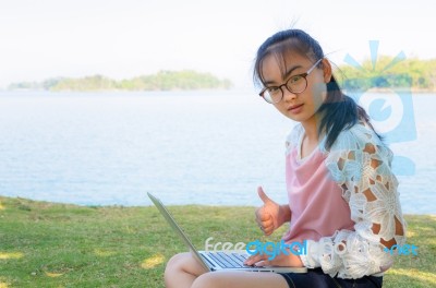 Young Girl With Laptop On The Grass Stock Photo