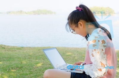 Young Girl With Laptop On The Grass Stock Photo