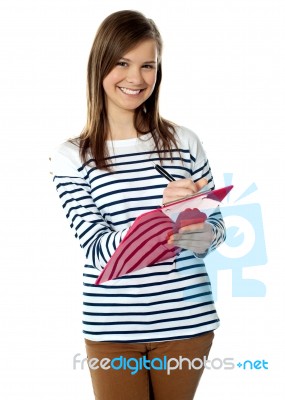 Young Girl Writing On Documents Stock Photo