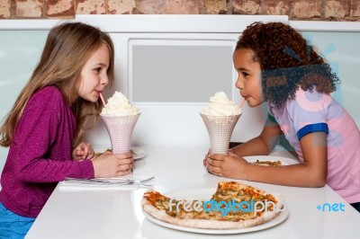 Young Girls Sipping Strawberry Shake Stock Photo