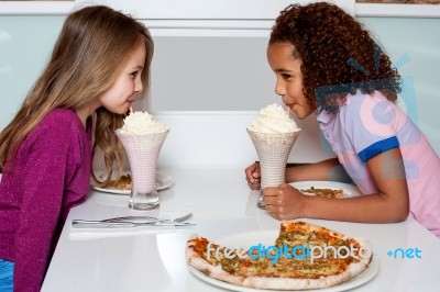 Young Girls Sipping Strawberry Shake Stock Photo