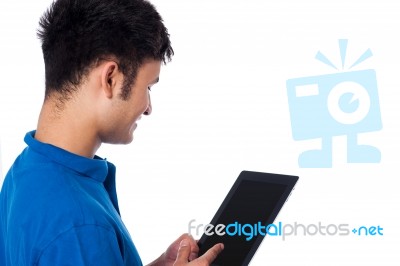 Young Guy Browsing On Tablet Device Stock Photo