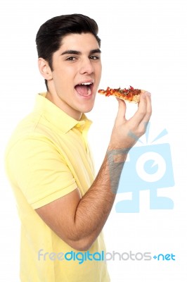 Young Guy With A Slice Of Pizza In Hand Stock Photo