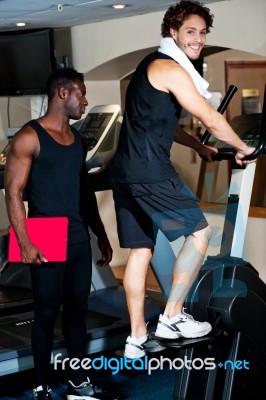 Young Guy With His Personal Trainer Beside Him Stock Photo