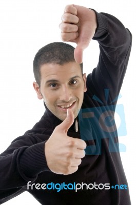 Young Guy With Thumbs Up And Down Stock Photo