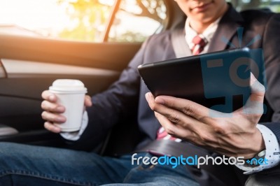 Young Handsome Businessman Working In Back Of Car And Using A Ta… Stock Photo