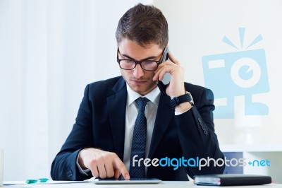 Young Handsome Man Working In His Office With Mobile Phone Stock Photo