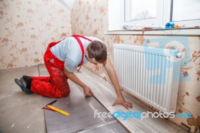 Young Handyman Installing Wooden Floor Stock Photo