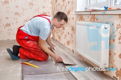 Young Handyman Installing Wooden Floor Stock Photo