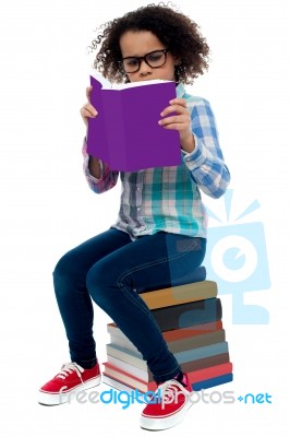 Young Kid Concentrating While Reading A Book Stock Photo