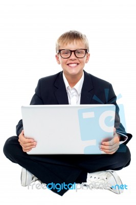 Young Kid Sitting On Laptop Stock Photo