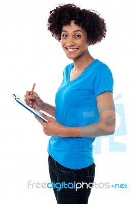 Young Lady Documenting Instructions On Clipboard Stock Photo