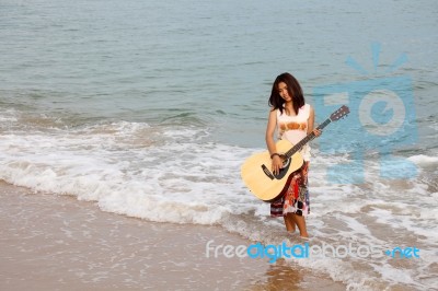 Young lady Playing Guitar at Beach Stock Photo