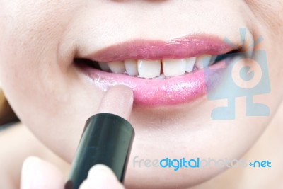 Young Lady Putting Lipstick Stock Photo