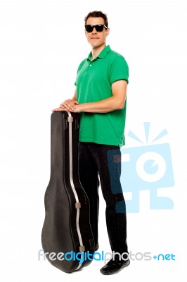 Young Male Holding Guitar Case Stock Photo