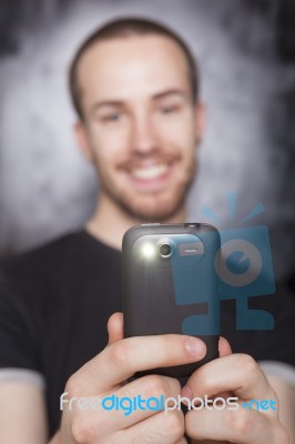 Young Male Holding Smartphone Stock Photo