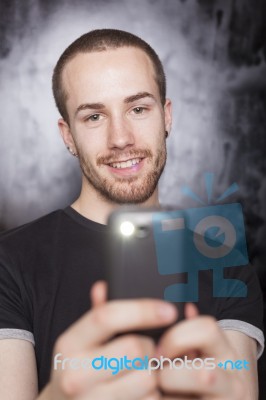 Young Male Holding Smartphone Stock Photo