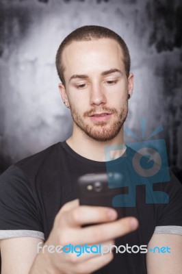 Young Male Holding Smartphone Stock Photo