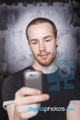 Young Male Holding Smartphone Stock Photo