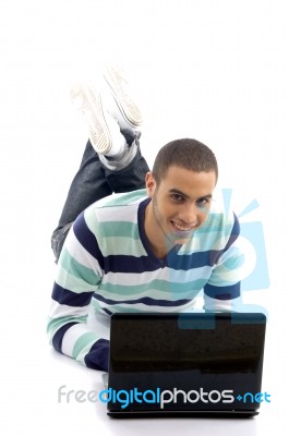 Young Male Lying On The Floor And Busy With Laptop Stock Photo