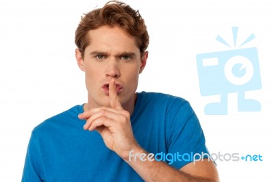 Young Male With Finger On His Lips Stock Photo