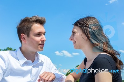 Young Man And Woman In Love Conversating With Blue Sky Stock Photo