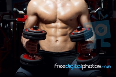 Young Man Doing Heavy Weight Exercise In Gym Stock Photo