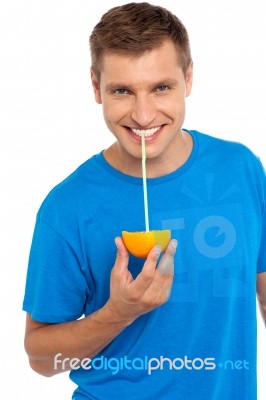 Young Man Drinking Orange Juice Stock Photo