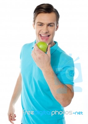 Young Man Eating Green Apple Stock Photo