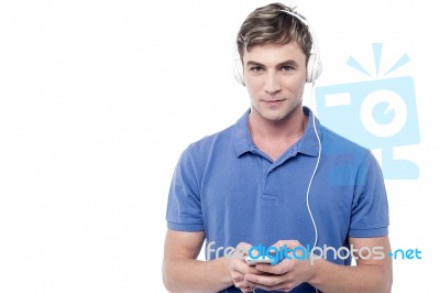 Young Man Enjoying Music And Using His Mobile Stock Photo