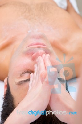 Young Man Getting A Face Massage From Masseuse Stock Photo