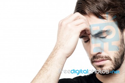 Young Man Holding Head In Hand Stock Photo