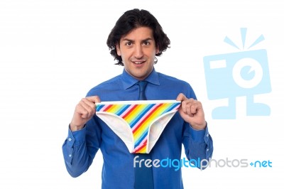 Young Man Holding Multicolored Underwear Stock Photo