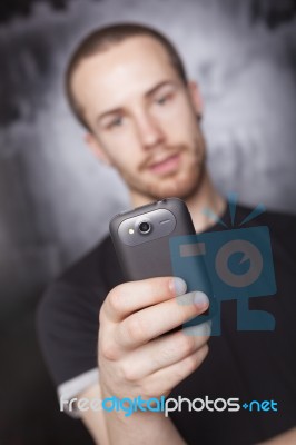 Young Man Holding Smartphone Stock Photo