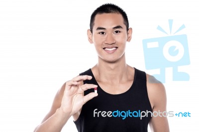 Young Man Holding Vitamin Pill Stock Photo