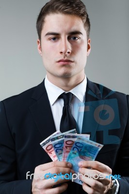 Young Man In Formalwear Holding Money Stock Photo