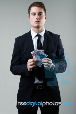 Young Man In Formalwear Holding Money Stock Photo