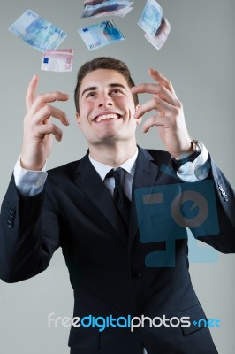 Young Man In Formalwear Throwing Money Stock Photo