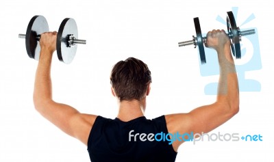 Young Man lifting Dumbbells Stock Photo