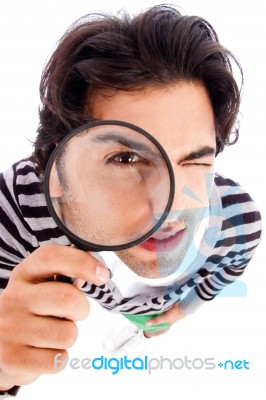 Young Man Looking Up With A Magnifying Glass Stock Photo