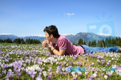 Young Man Lying Alone On Grass Stock Photo