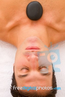 Young Man Receiving Hot Stone Treatment Stock Photo