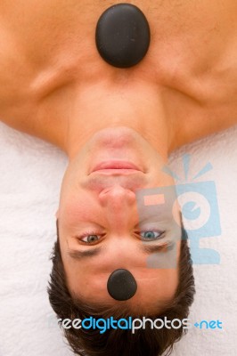 Young Man Receiving Stone Treatment Spa Stock Photo