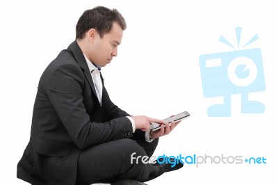 Young Man Sitting On A Floor And Using Tablet Pc Stock Photo