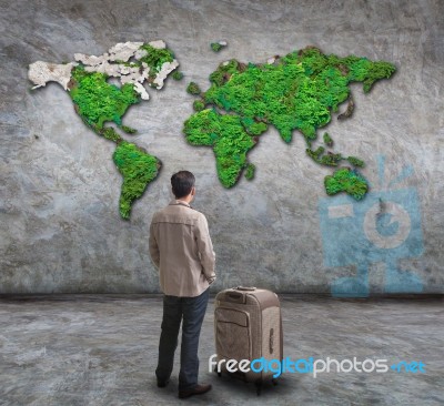 Young Man Standing And Looking To World Map On Wall Stock Photo