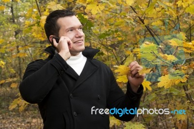 Young Man Talking On Cellphone At Park Stock Photo