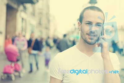 Young Man Talking With Cell Phone Walking Stock Photo