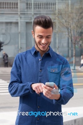 Young Man Using A Smart Phone Stock Photo